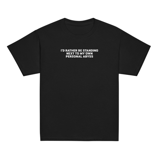 "I'd rather be standing next to my own personal abyss" printed on a black youth classic tee laying on a flat surface