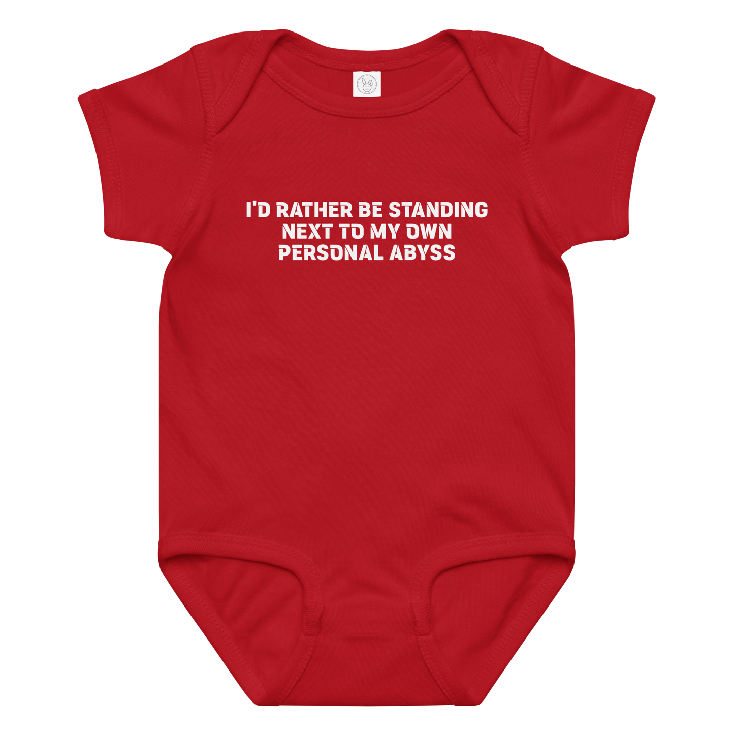 "I'd rather be standing next to my own personal abyss" printed on a red baby jersey bodysuit laying on a flat surface amongst other clothes