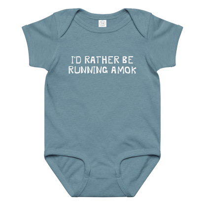 "I’d rather be running amok" printed on a vintage indigo baby jersey bodysuit laying on a flat surface amongst other clothes