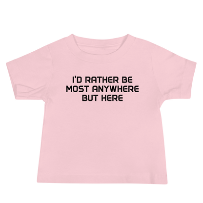"I’d rather be most anywhere but here" printed on a pink baby jersey short sleeve tee laying on a flat surface