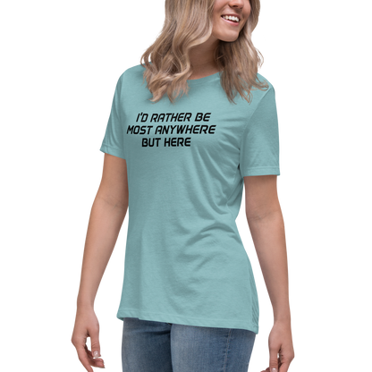 "I’d rather be most anywhere but here" printed on a heather blue lagoon women's relaxed t-shirt worn by a female