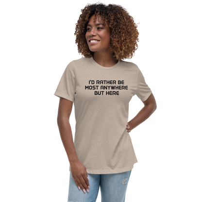 "I’d rather be most anywhere but here" printed on a heather stone women's relaxed t-shirt worn by a female