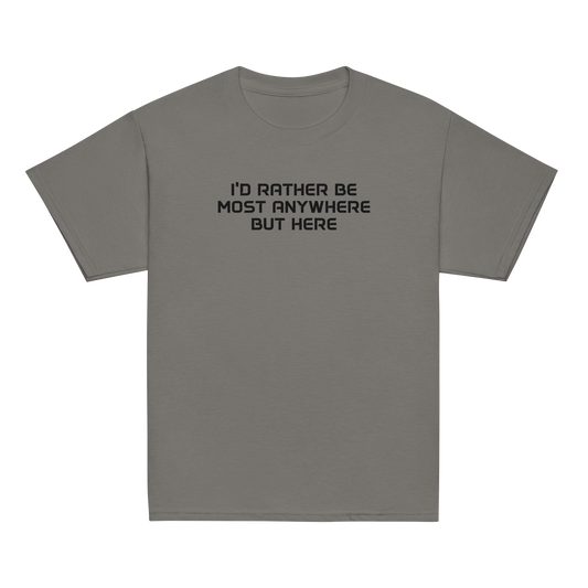 "I’d rather be most anywhere but here" printed on a charcoal youth classic tee laying on a flat surface