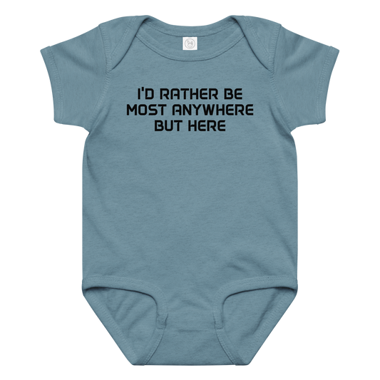 "I’d rather be most anywhere but here" printed on a vintage indigo baby jersey bodysuit laying on a flat surface amongst other clothes