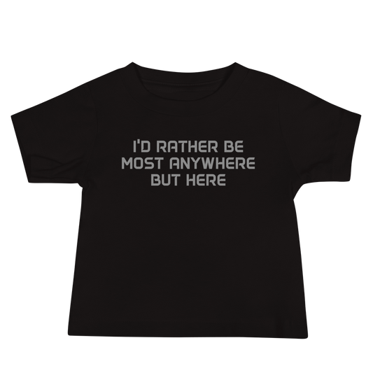 "I’d rather be most anywhere but here" printed on a black baby jersey short sleeve tee laying on a flat surface