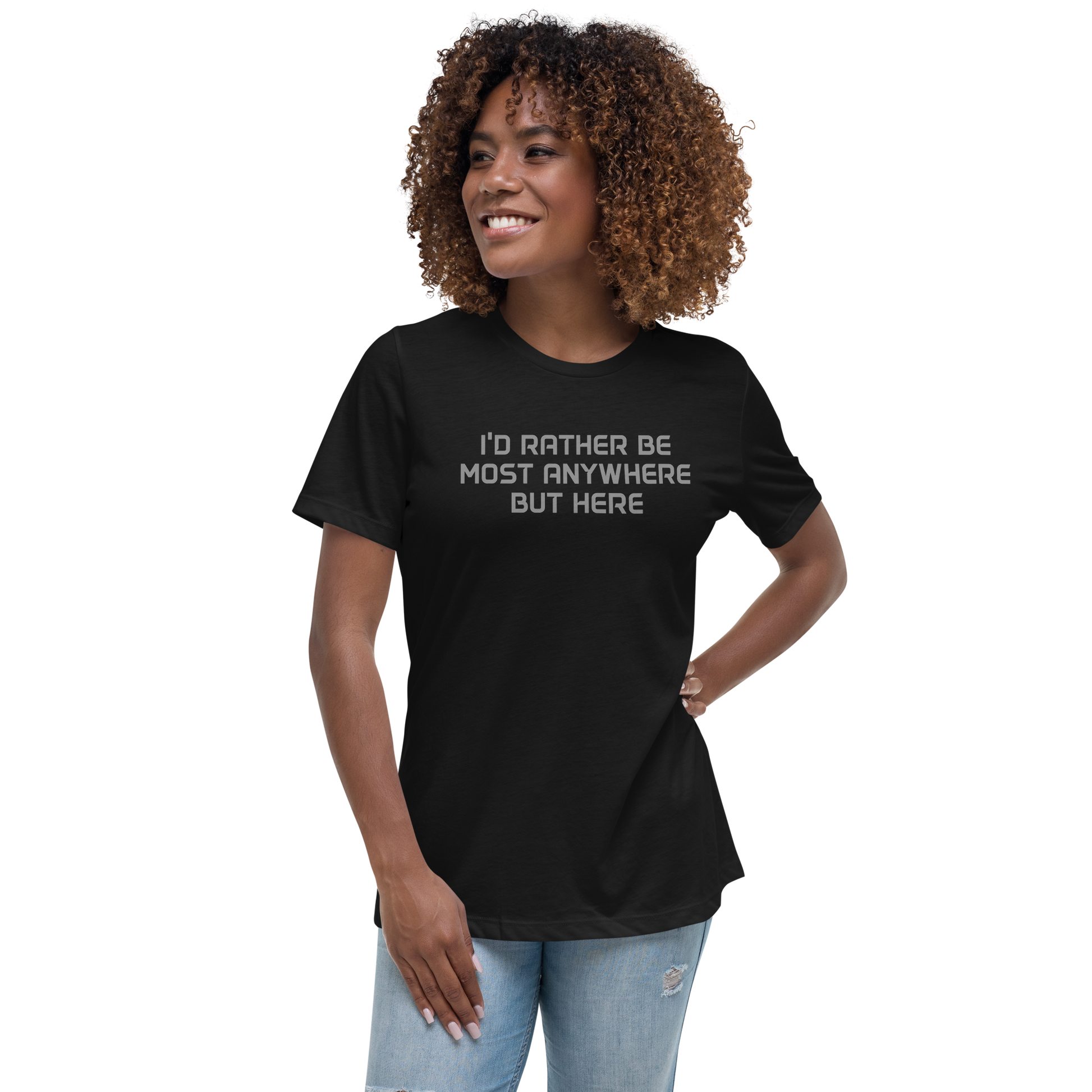 "I’d rather be most anywhere but here" printed on a black women's relaxed t-shirt worn by a female