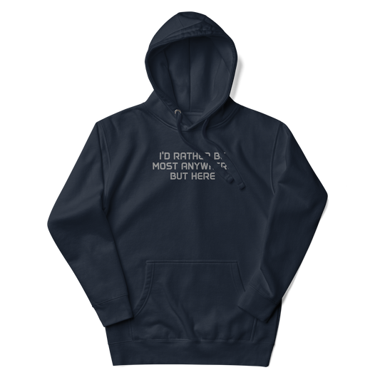 "I’d rather be most anywhere but here" printed on a navy blazer unisex hoodie laying on a flat surface with the hood up