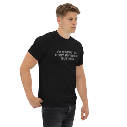 "I’d rather be most anywhere but here" printed on a black unisex classic tee worn by a male