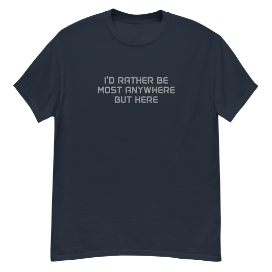 "I’d rather be most anywhere but here" printed on a navy unisex classic tee laying on a flat surface