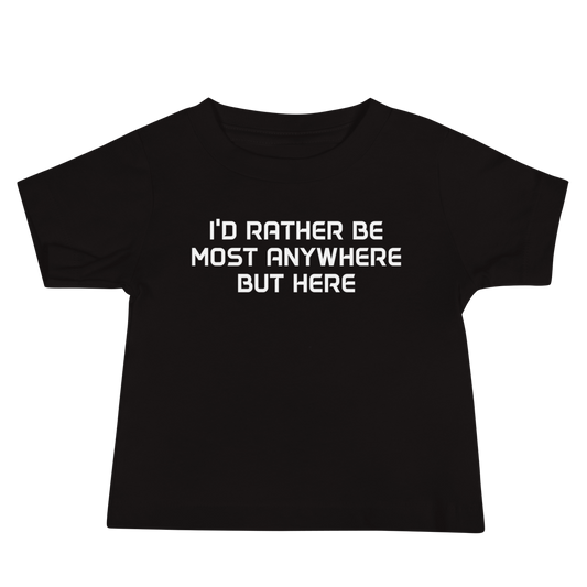 "I’d rather be most anywhere but here" printed on a black baby jersey short sleeve tee laying on a flat surface