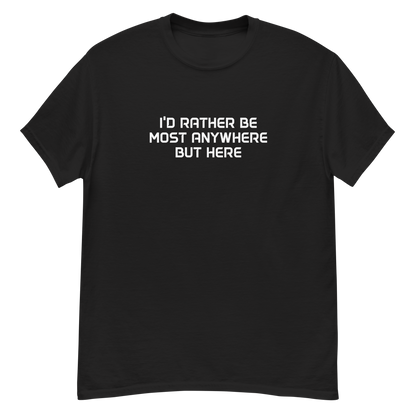 "I’d rather be most anywhere but here" printed on a black unisex classic tee laying on a flat surface