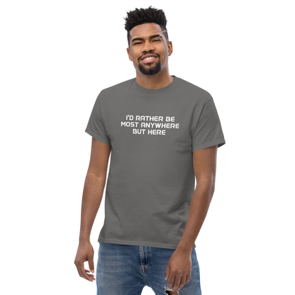 "I’d rather be most anywhere but here" printed on a charcoal unisex classic tee worn by a male