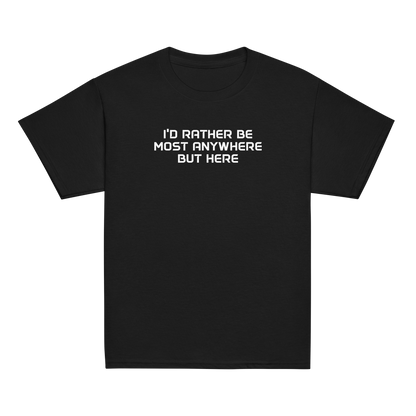 "I’d rather be most anywhere but here" printed on a black youth classic tee laying on a flat surface