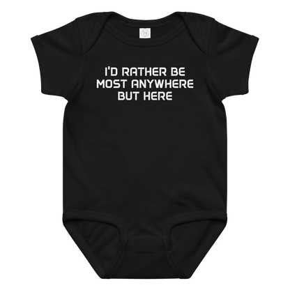 "I’d rather be most anywhere but here" printed on a black baby jersey bodysuit laying on a flat surface amongst other clothes