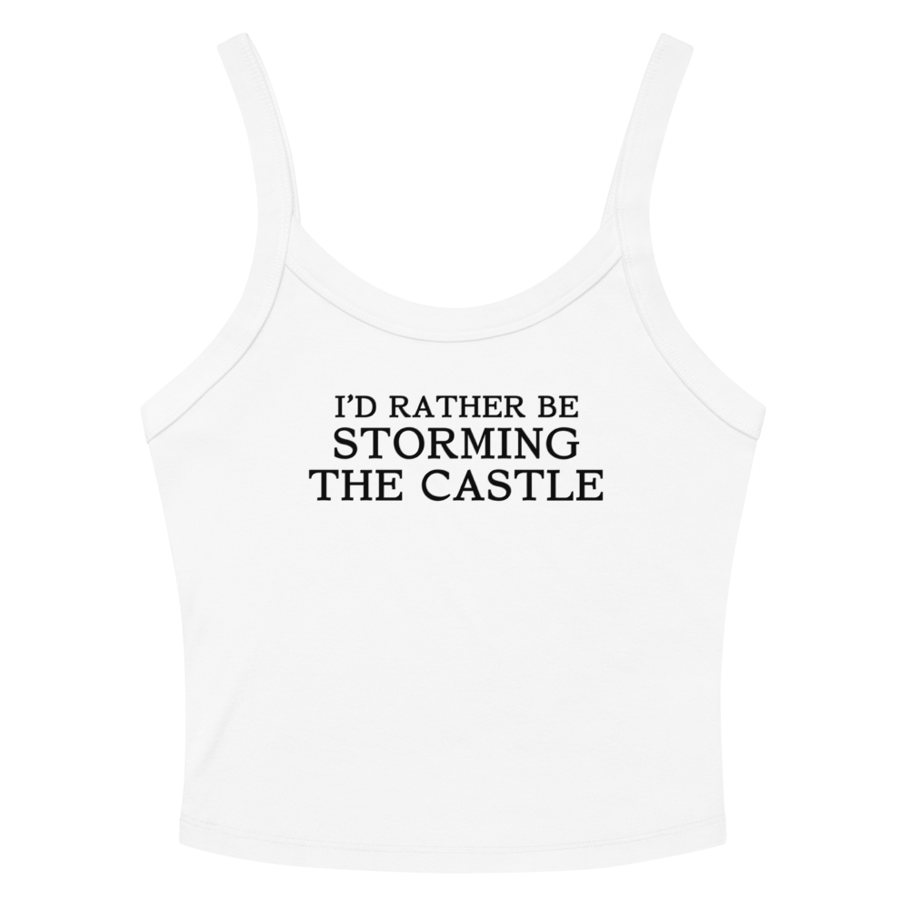 "I'd rather be storming the castle" printed on a solid white blend women's micro-rib tanktop laying on a flat surface amongst sunglasses and shorts