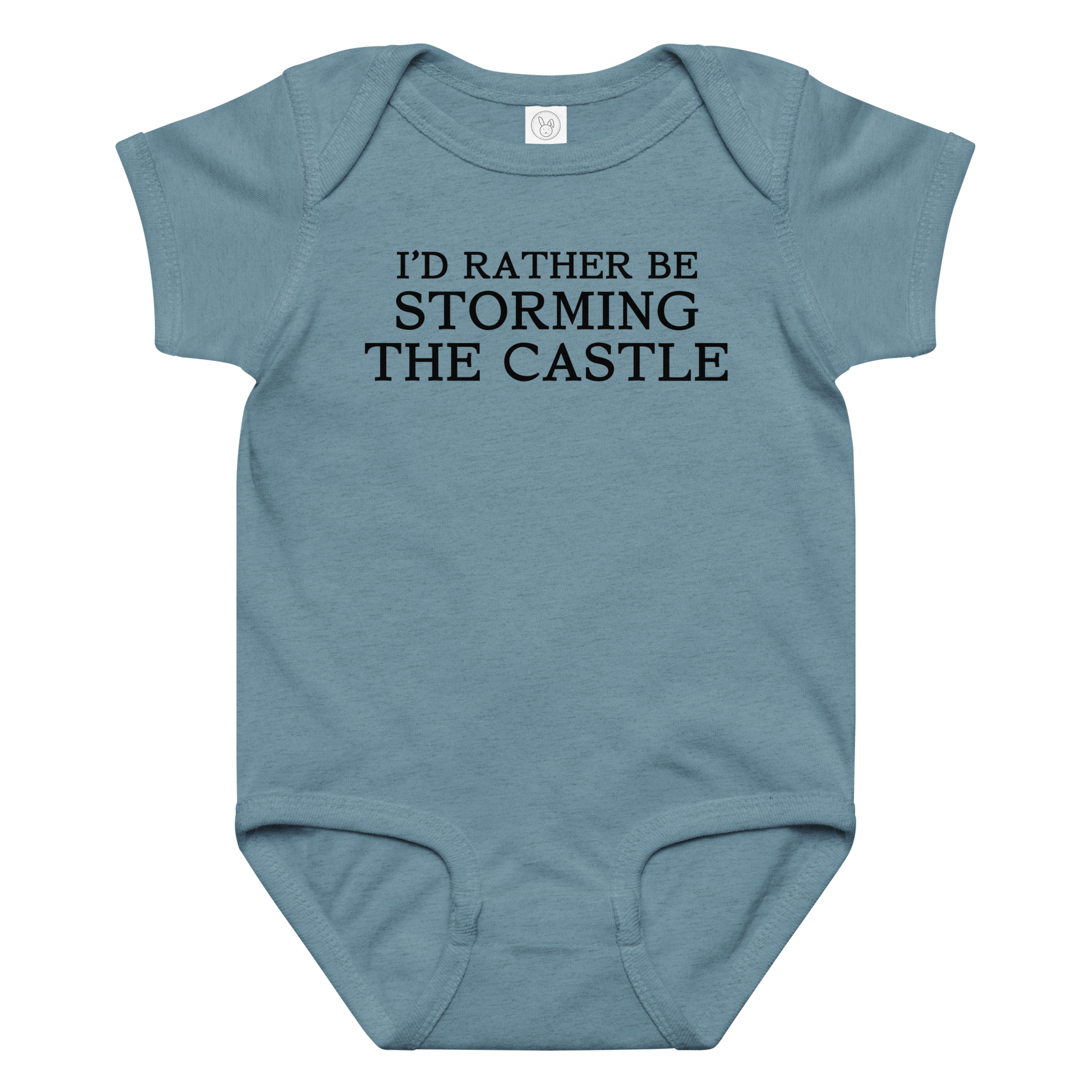 "I'd rather be storming the castle" printed on a vintage indigo baby jersey bodysuit laying on a flat surface amongst other clothes