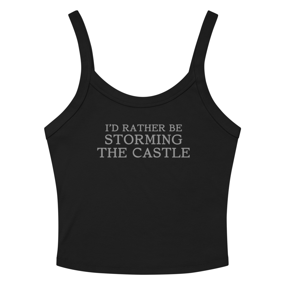 "I'd rather be storming the castle" printed on a solid black blend women's micro-rib tanktop laying on a flat surface amongst sunglasses and shorts