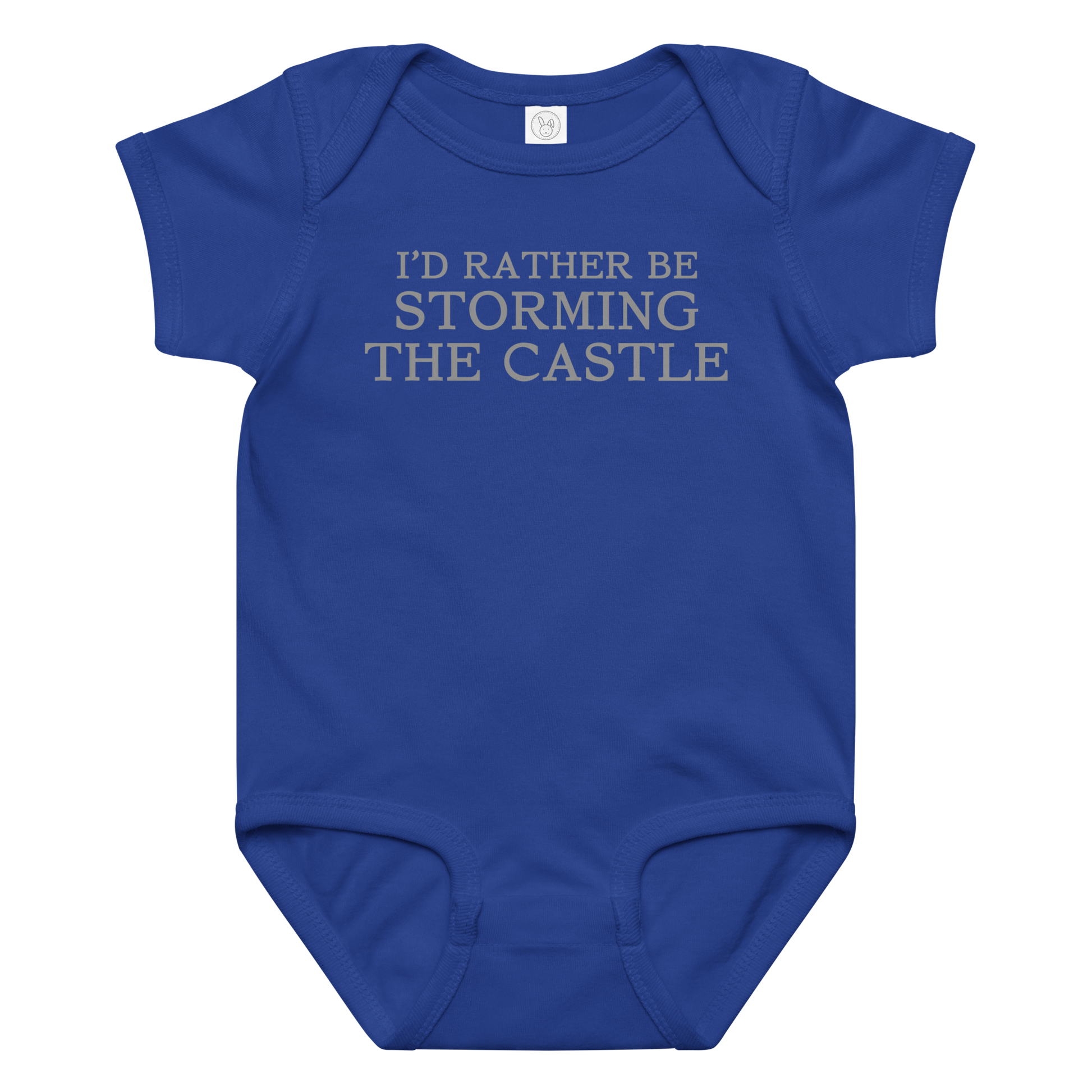 "I'd rather be storming the castle" printed on a royal baby jersey bodysuit laying on a flat surface amongst other clothes