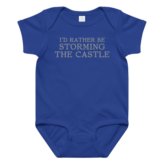 "I'd rather be storming the castle" printed on a royal baby jersey bodysuit laying on a flat surface amongst other clothes