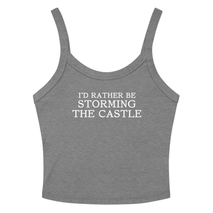 "I'd rather be storming the castle" printed on a athletic heather women's micro-rib tanktop laying on a flat surface amongst sunglasses and shorts