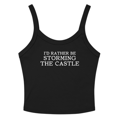 "I'd rather be storming the castle" printed on a solid black blend women's micro-rib tanktop laying on a flat surface amongst sunglasses and shorts