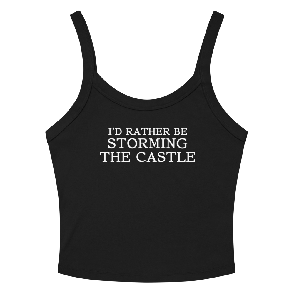"I'd rather be storming the castle" printed on a solid black blend women's micro-rib tanktop laying on a flat surface amongst sunglasses and shorts