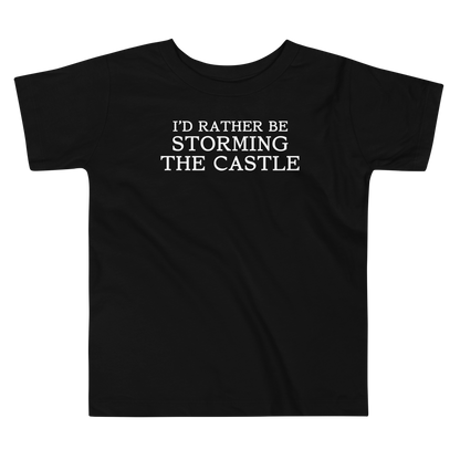 "I'd rather be storming the castle" printed on a black toddler short sleeve tee laying on a flat surface