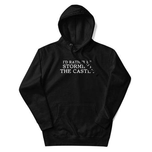 "I'd rather be storming the castle" printed on a black unisex hoodie laying on a flat surface with the hood up
