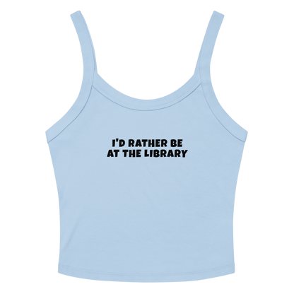 "I’d rather be at the library" printed on a solid baby blue blend women's micro-rib tanktop laying on a flat surface amongst sunglasses and shorts