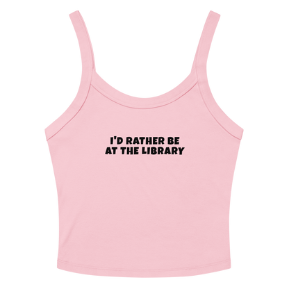 "I’d rather be at the library" printed on a solid pink blend women's micro-rib tanktop laying on a flat surface amongst sunglasses and shorts
