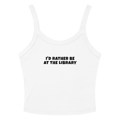 "I’d rather be at the library" printed on a solid white blend women's micro-rib tanktop laying on a flat surface amongst sunglasses and shorts