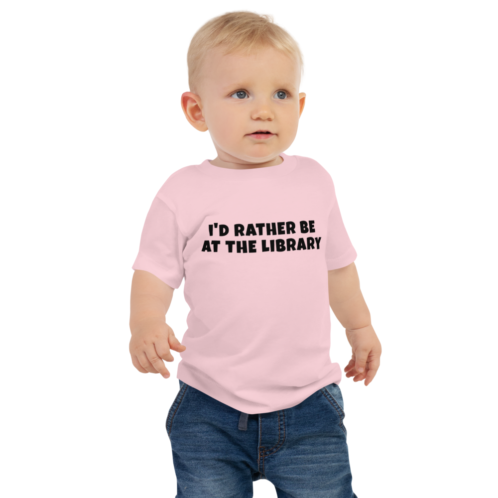 "I’d rather be at the library" printed on a pink baby jersey short sleeve tee worn by a male
