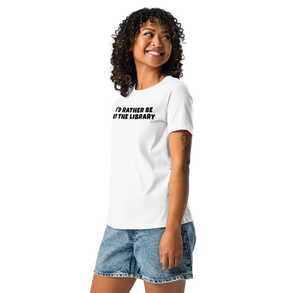 "I’d rather be at the library" printed on a white women's relaxed t-shirt worn by a female