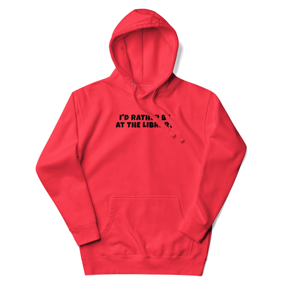 "I’d rather be at the library" printed on a team red unisex hoodie laying on a flat surface with the hood up