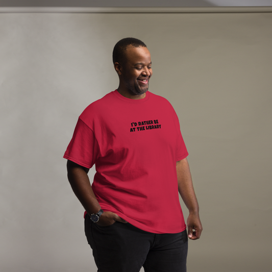 "I’d rather be at the library" printed on a cardinal unisex classic tee worn by a male