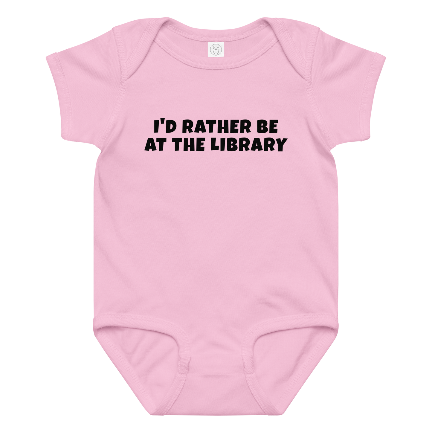 "I’d rather be at the library" printed on a pink baby jersey bodysuit laying on a flat surface amongst other clothes