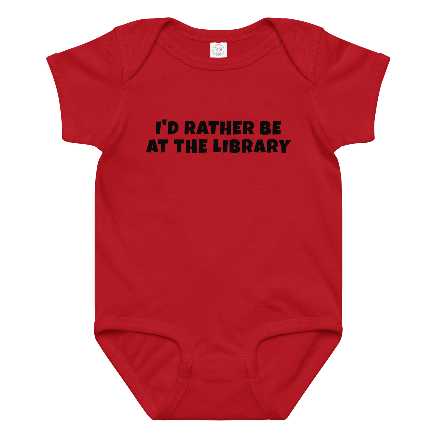 "I’d rather be at the library" printed on a red baby jersey bodysuit laying on a flat surface amongst other clothes