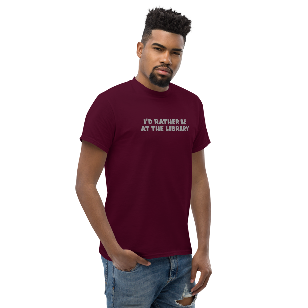 "I’d rather be at the library" printed on a maroon unisex classic tee worn by a male