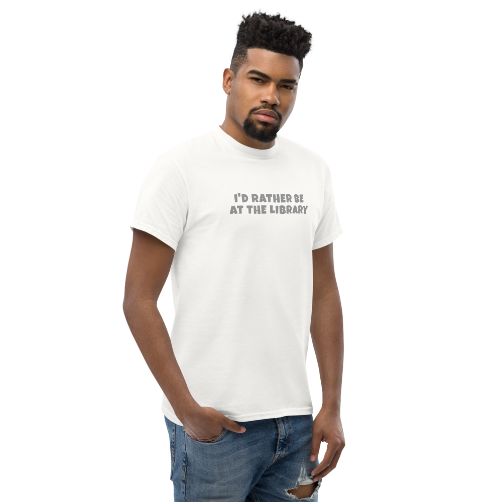 "I’d rather be at the library" printed on a white unisex classic tee worn by a male