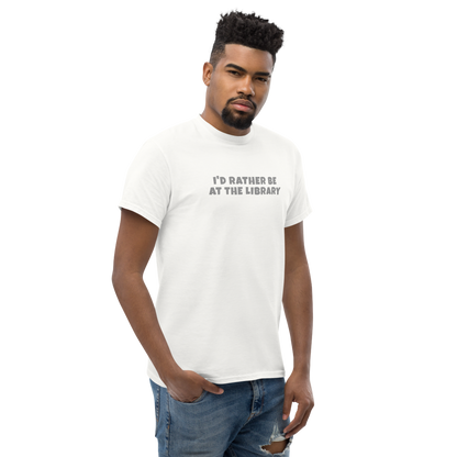 "I’d rather be at the library" printed on a white unisex classic tee worn by a male