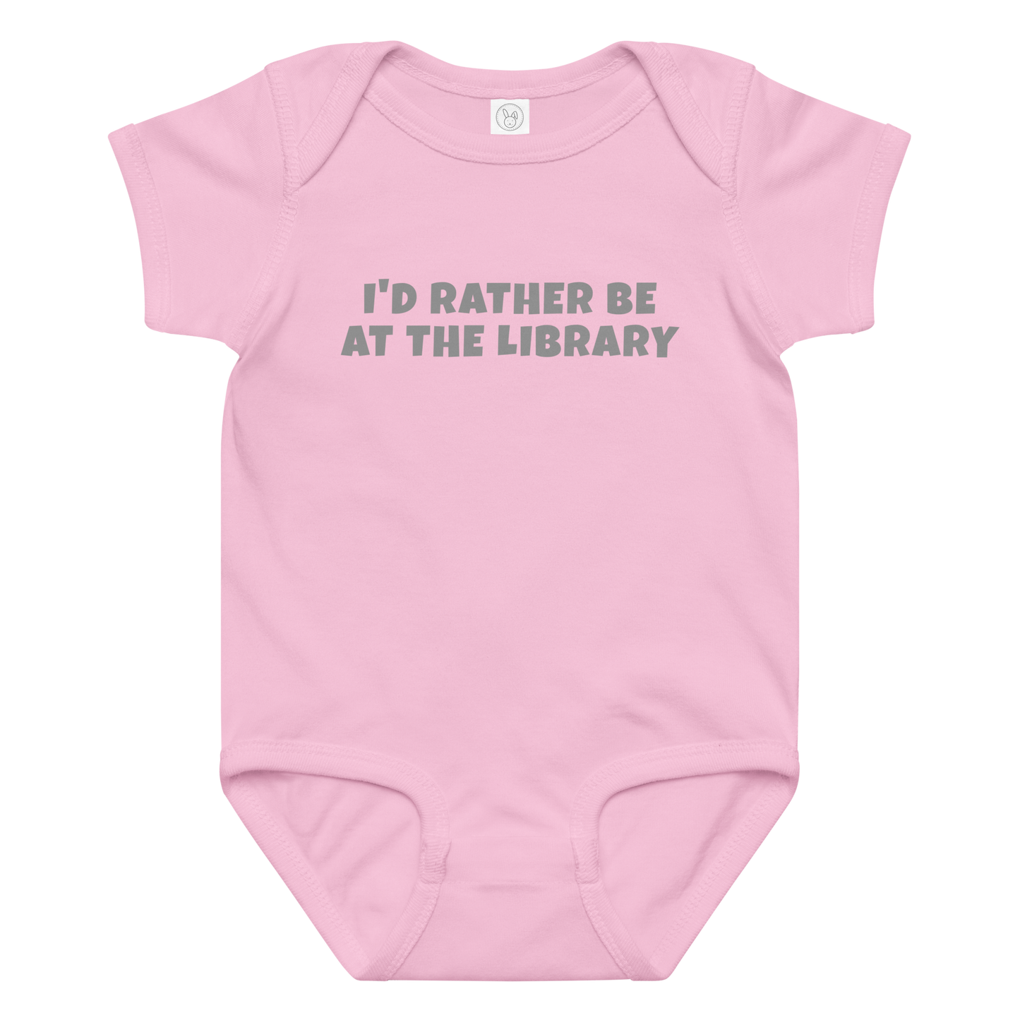 "I’d rather be at the library" printed on a pink baby jersey bodysuit laying on a flat surface amongst other clothes