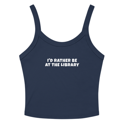 "I’d rather be at the library" printed on a solid navy blend women's micro-rib tanktop laying on a flat surface amongst sunglasses and shorts