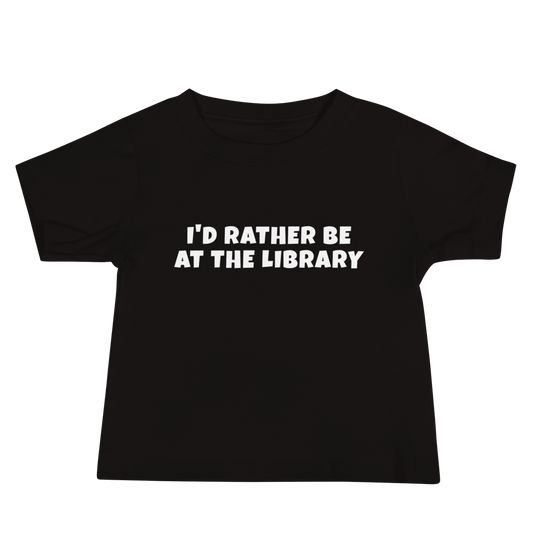"I’d rather be at the library" printed on a black baby jersey short sleeve tee laying on a flat surface