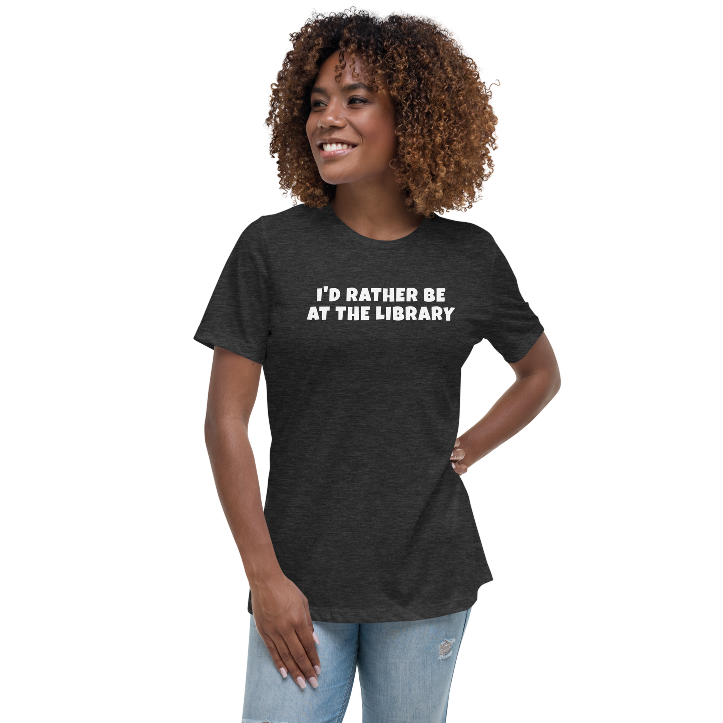 "I’d rather be at the library" printed on a dark grey heather women's relaxed t-shirt worn by a female