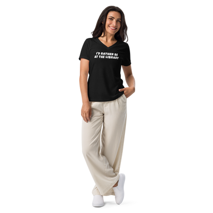 "I’d rather be at the library" printed on a solid black blend women's relaxed v-neck t-shirt worn by a female