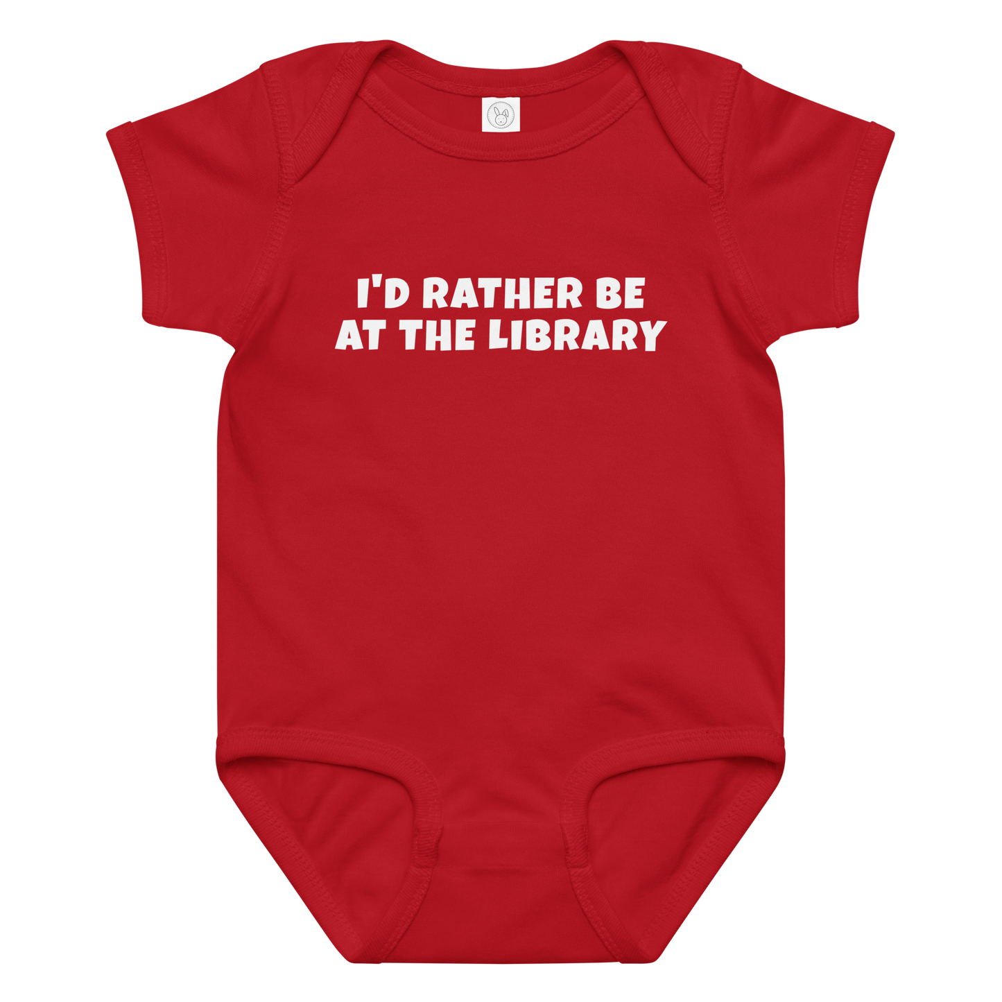 "I’d rather be at the library" printed on a red baby jersey bodysuit laying on a flat surface amongst other clothes