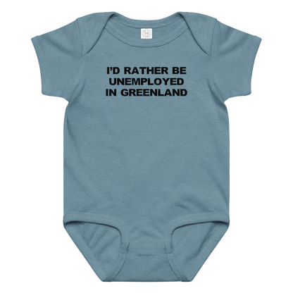 "I'd rather be unemployed in greenland" printed on a vintage indigo baby jersey bodysuit laying on a flat surface amongst other clothes