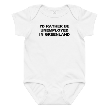 "I'd rather be unemployed in greenland" printed on a white baby jersey bodysuit laying on a flat surface amongst other clothes