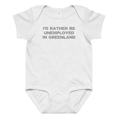 "I'd rather be unemployed in greenland" printed on a ash baby jersey bodysuit laying on a flat surface amongst other clothes