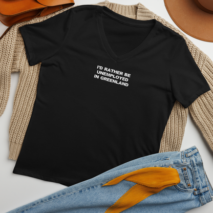 "I'd rather be unemployed in greenland" printed on a solid black blend women's relaxed v-neck t-shirt laying on a flat surface amongst other clothes